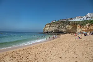 Adults Prints: Visitors enjoy a sunny day at Carvoeiro beach in Algarve Portugal with golden sand and clear water