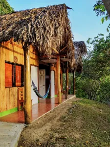 Hammock Prints: Visitors enjoy a unique stay in a wooden house with a thatched roof in Lanquin, Guatemala