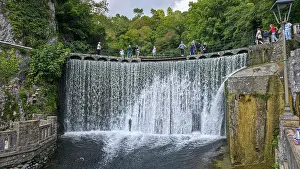 Waterfall Prints: Visitors enjoy the view of the artificial waterfall while walking along the paved path in New Athon