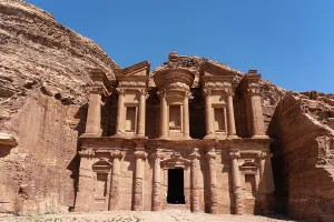 Sandstone Prints: Visitors explore the Monastery at Al Dayr in Petra, Jordan under bright sunny sky