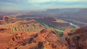 Canyonlands Prints: Visitors explore views of rocky terrain and winding river in Canyonlands National Park at sunset in Utah USA