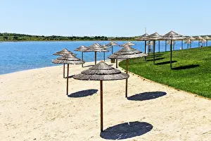 Friends Prints: Visitors relax under umbrellas at Mourao beach on Alqueva lake in Portugal during sunny weather