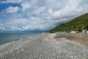 Chairs Prints: Visitors walk along Gagra beach in Abkhazia while enjoying the view of the water