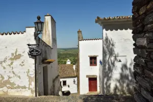Alentejo Prints: Visitors walk along the narrow streets of Monsaraz while exploring the traditional white houses in Alentejo region of
