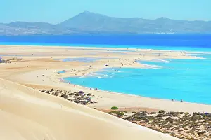 Dunes Prints: Visitors walk along Sotavento Beach while enjoying the sun and water in Fuerteventura
