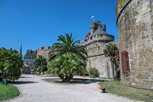 Brittany Prints: Visitors walk through the walled city of Saint-Malo with palm trees and historic architecture in Brittany