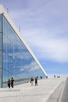 Visitors walking outside the Oslo Opera house exterior in summer sunshine Visitors walking outside the Oslo Opera house exterior in summer sunshine