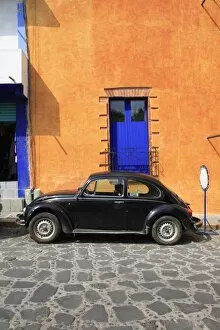 Volkswagen Beetle parked on cobblestone street, Tepoztlan, near Mexico City where many city dwellers spend weekends