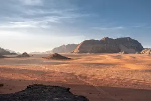 Wadi Rum Prints: Wadi Rum plain at sunrise with soft light over the sand dunes and mountains