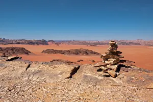 Cairn Prints: Wadi Rum red desert with some stone stacked in a pile in the foreground