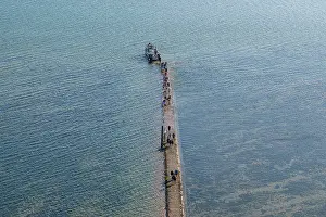 Maritime Prints: Walkway leads to lighthouse of Cordouan during low tide with visitors walking along the path in France