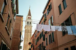 Castello Prints: Washing hangs on clotheslines against bell tower in Castello area of Venice on a sunny day