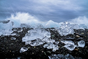 Black Sand Prints: Water crashing over the ice and black sandy beach at Jokulsarlon, Iceland, Polar Regions