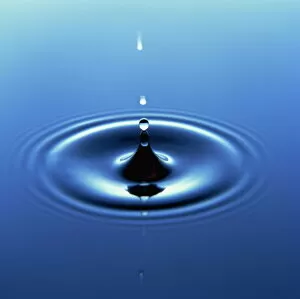 Natural Phenomena Collection: Water droplet hitting water surface creating ripples