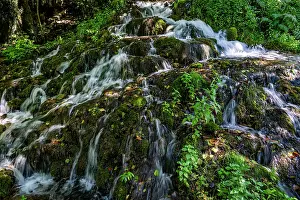 Flowing Prints: Water flows over rocks and greenery at Strbacki buk waterfall in Una National Park in Bosnia and Herzegovina