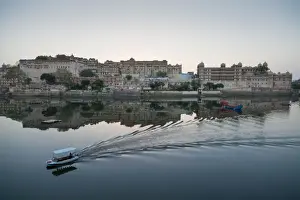 Udaipur Prints: A water taxi passing the City Palace reflected in the still dawn waters of Lake Pichola
