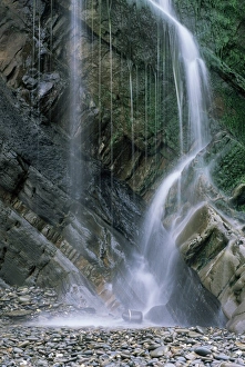 Strata Prints: Waterfall with wet rocks and pebbles taken from beach, Cornwall, England