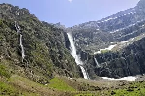 Waterfalls cascade down the karst limestone cliffs of the Cirque de Gavarnie, Pyrenees National Park, Hautes-Pyrenees