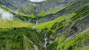 Waterfalls Prints: Waterfalls flow through Tschinglengorge in Sardona National Park in Switzerland with green mountains and rocky terrain