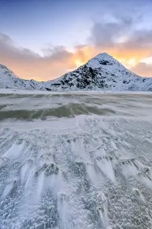 Uttakleiv Prints: Wave advances towards the shore of the beach surrounded by snowy peaks at dawn, Uttakleiv