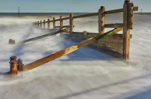 Channel Prints: Waves crash around a groyne on the beach at Teignmouth