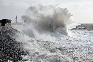 Waves crash against the harbour wall at Porthcawl, Bridgend, Wales, United Kingdom