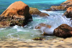 Getaway Prints: Waves crash over rocks at Anse Lazio beach in Seychelles during a sunny day with turquoise water and soft sand nearby