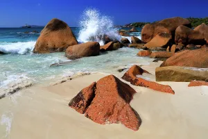 Enjoyment Prints: Waves crash on rocks at a beautiful beach with clear water and bright sunlight in Seychelles