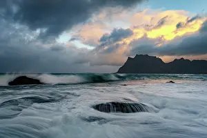 Foam Prints: Waves crash on rocks along the rough sea at Uttakleiv beach during sunset in Norway's Lofoten Islands