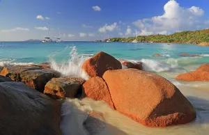 Enjoyment Prints: Waves crash against rocks along the shore at Anse Lazio beach in Seychelles during a bright sunny day