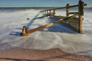 Channel Prints: Waves crash against wooden groyne at beach in Teignmouth