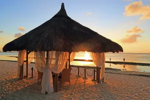 Romance Prints: Wedding gazebo during sunset on a beach in Mauritius with calm waters and distant people by the shore