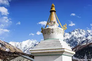 Stupa Prints: White Buddhist stupa with golden spire standing before the snow-covered Gangchempo and Tserko Ri in Langtang Valley