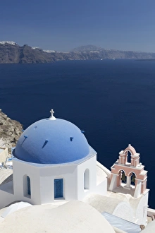 White church with blue dome and pink belltower overlooking the Caldera, Oia, Santorini White church with blue dome and pink belltower overlooking the Caldera, Oia, Santorini
