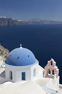 Bell Tower Prints: White church with blue dome and pink belltower overlooking the Caldera, Oia, Santorini