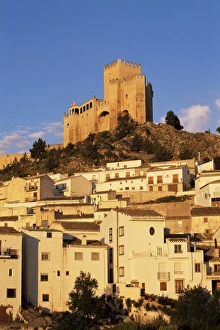 Whitewashed village houses dwarfed by the Castillo