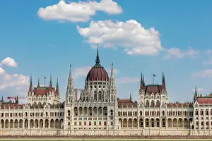 Danube Prints: Wide-angle view of the Hungarian Parliament Building on the Danube River under a blue sky in Budapest