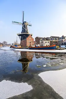 Windmills Prints: Windmill De Adriaan reflected in the canal of icy river Spaarne, Haarlem