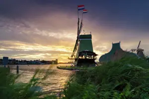 Dutch Prints: Windmill at sunset in summer with flags in Zaanse Schans, North Holland, Netherlands