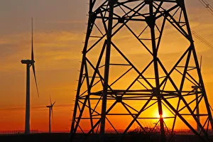 Orange Colour Prints: Windmills, pylon and power lines in morning light, Germany, Europe
