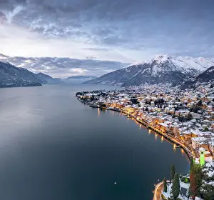Lake Como Prints: Winter sunrise over the illuminated lakeside town of Gravedona and snowy peaks, Lake Como