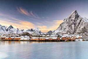 Nordland Gallery: Winter sunset over snowcapped mountains and Sakrisoy village by the frozen sea, Reine, Nordland