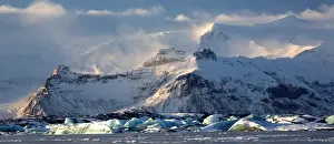 South Iceland Prints: Winter view over frozen Jokulsarlon Glacier Lagoon showing blue icebergs covered in snow