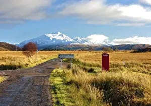 Telephone Box Prints: Winter view of a red telephone box and road toward snow covered Beinn Resipol mountain