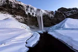 South Iceland Prints: Winter view of Seljalandsfoss Waterfall at dusk with snow covered foreground