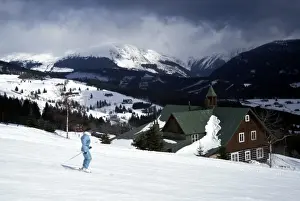 Overcast Sky Prints: Winter view of skier on slopes at Pec Pod Snezkou with Snezka Mountain