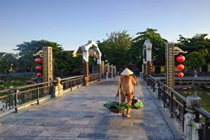 Bags Prints: A woman carrying baskets on a yoke over the Lantern Bridge in Hoi An, Quang Nam, Vietnam