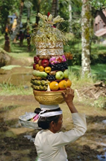 Woman carrying food offerings on her head Woman carrying food offerings on her head