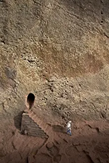 Rock Cliffs Prints: A woman emerges from a tunnel leading to the rock-hewn church of Bet Amanuel