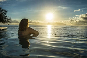 Contemplation Gallery: Woman enjoying the sunset in a swimming pool with Moorea in the background, Papeete